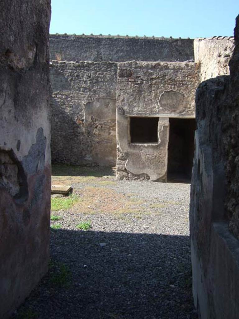 I.7.11 Pompeii. December 2006. Two rooms opposite entrance I.7.11.
On the right is the cubiculum and on the left is a ruined exedra.
In the ruined exedra, clearly recognised upon excavation were the remains of a wooden carbonized box.
Found in this were the four bronze “Placentarius” statuettes.  
