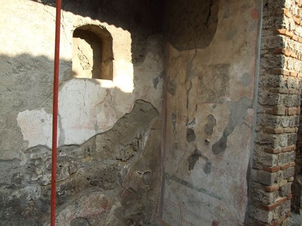 I.7.11 Pompeii. December 2006. Remains of lararium painting with niche set into the wall above it. On the south wall can be seen the remains of a painting.


