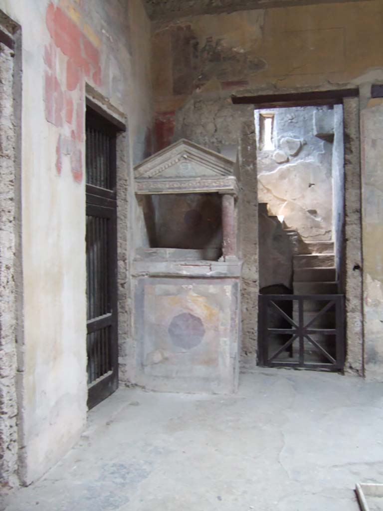 I.10.4 Pompeii. May 2006. 
North-west corner of atrium with doorway to room 5, the lararium and doorway to room 2.
