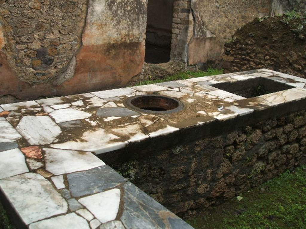 II.4.7 Pompeii. December 2005. Food counter and door in east wall to triclinium.
