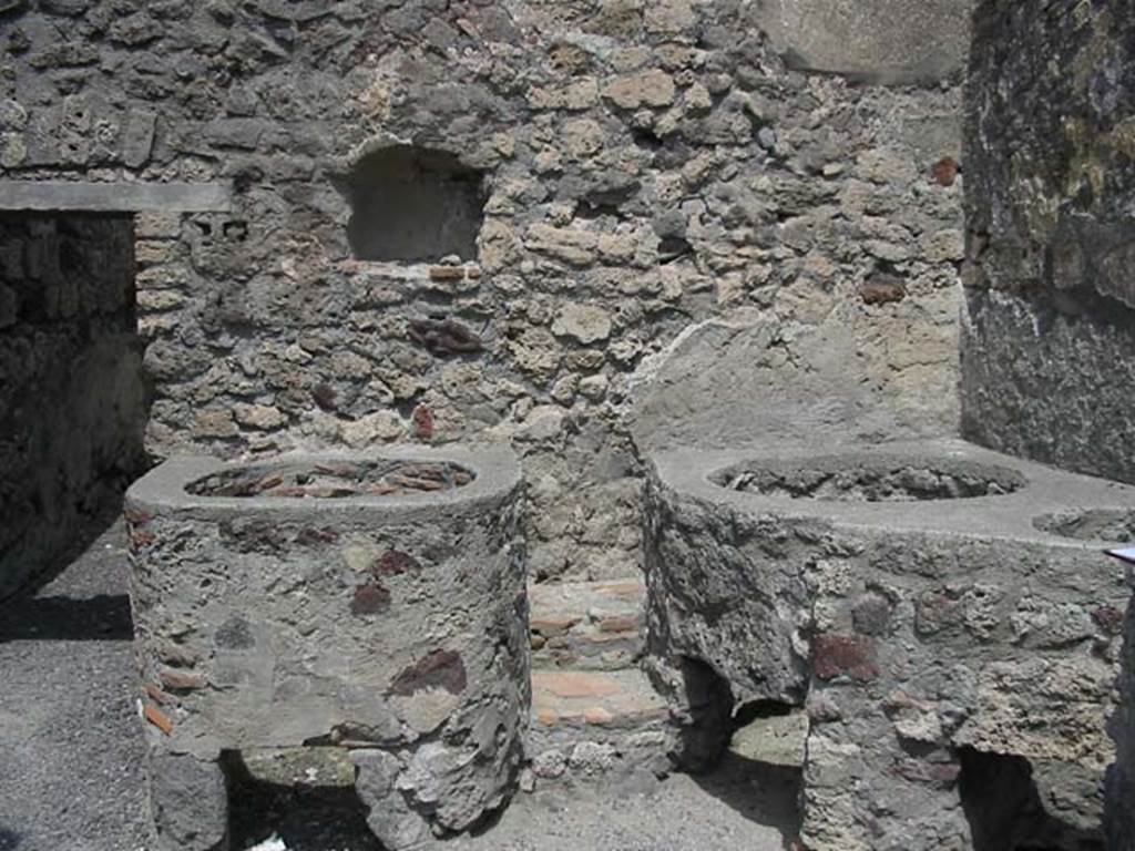 V.1.5 Pompeii. May 2003. Door to rear room in north wall with niche, and boilers or kettles nearby.  Photo courtesy of Nicolas Monteix.
