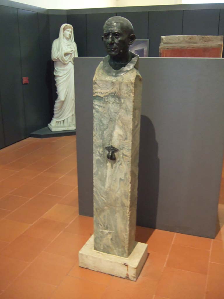 V.1.26 Pompeii. May 2006. Bronze herm bust found in atrium “b” near tablinum of V.1.26. 
On the marble base is the wording Genio L nostri Felix L. 
Now in Naples Archaeological Museum. Inventory number 110663.


