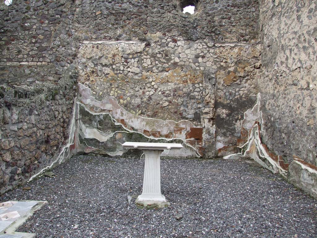 VI.7.23 Pompeii. December 2006. Table in triclinium, with walls showing many levels of painted plaster.
The beautiful flooring was coloured marble opus sectile of square and triangular tiles, see sample in lower left.
