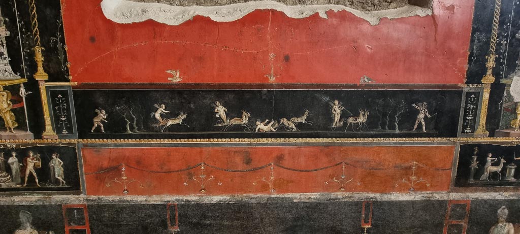 VI.15.1 Pompeii. January 2023. 
East wall with painted panel of cupids in a race between chariots pulled by deer. Photo courtesy of Miriam Colomer.
