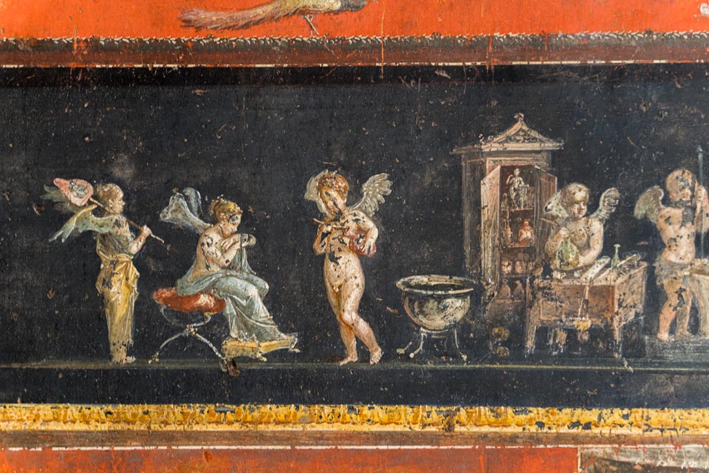 VI.15.1 Pompeii. March 2023. 
Lower east wall at south end, part of painted panel of cupids making perfumed oil. Photo courtesy of Johannes Eber.
