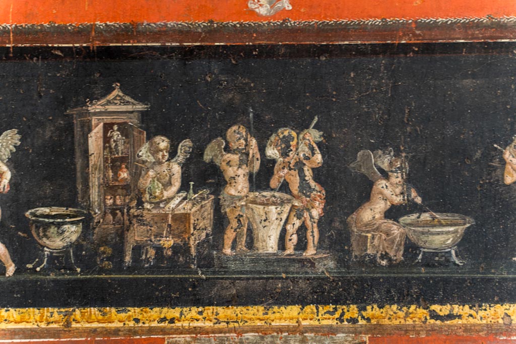 VI.15.1 Pompeii. March 2023. Lower east wall at south end, detail of cupids making perfumed oil. Photo courtesy of Johannes Eber.