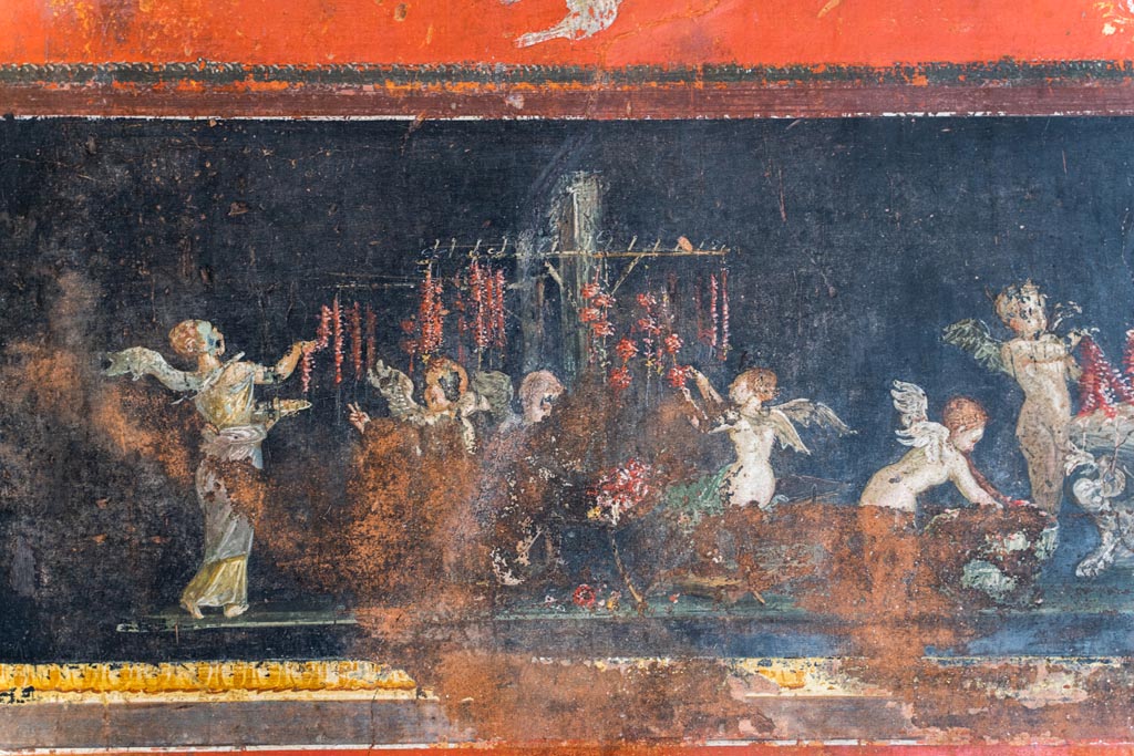 VI.15.1 Pompeii. March 2023. 
East wall in the south-east corner part of painted panel of cupids as flower dealers, picking and selling flowers and making garlands.
Photo courtesy of Johannes Eber.
