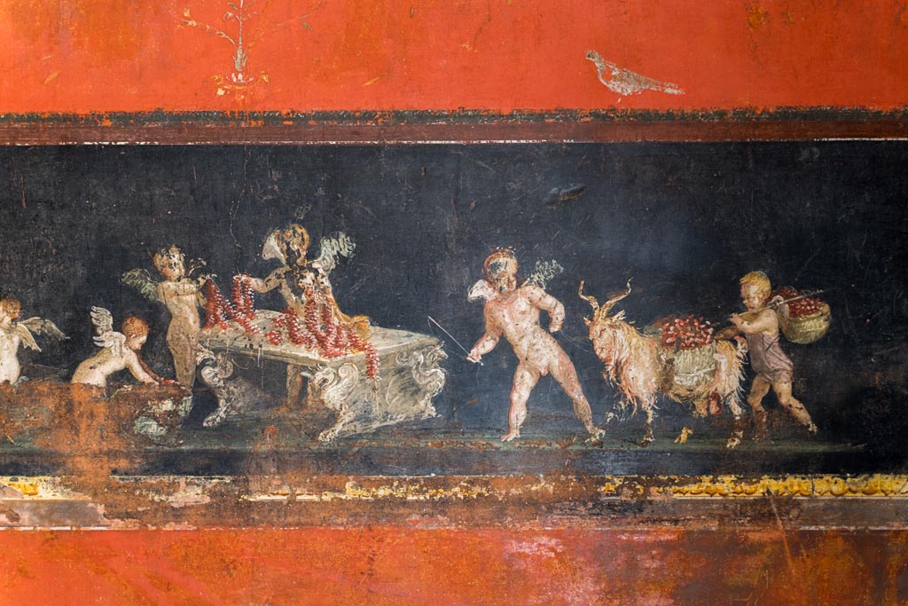 VI.15.1 Pompeii. March 2023. 
East wall in the south-east corner part of painted panel of cupids as flower dealers, picking and selling flowers and making garlands.
Photo courtesy of Johannes Eber.
