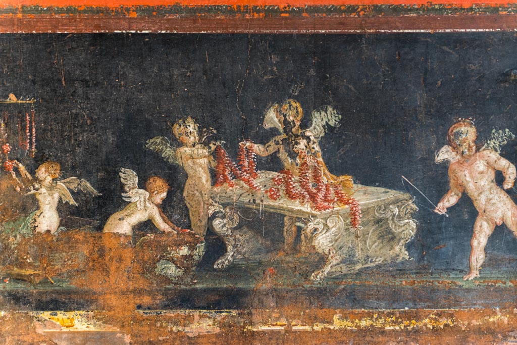 VI.15.1 Pompeii. March 2023. 
East wall in the south-east corner, part of painted panel of cupids as flower dealers, picking and selling flowers and making garlands.
Photo courtesy of Johannes Eber.
