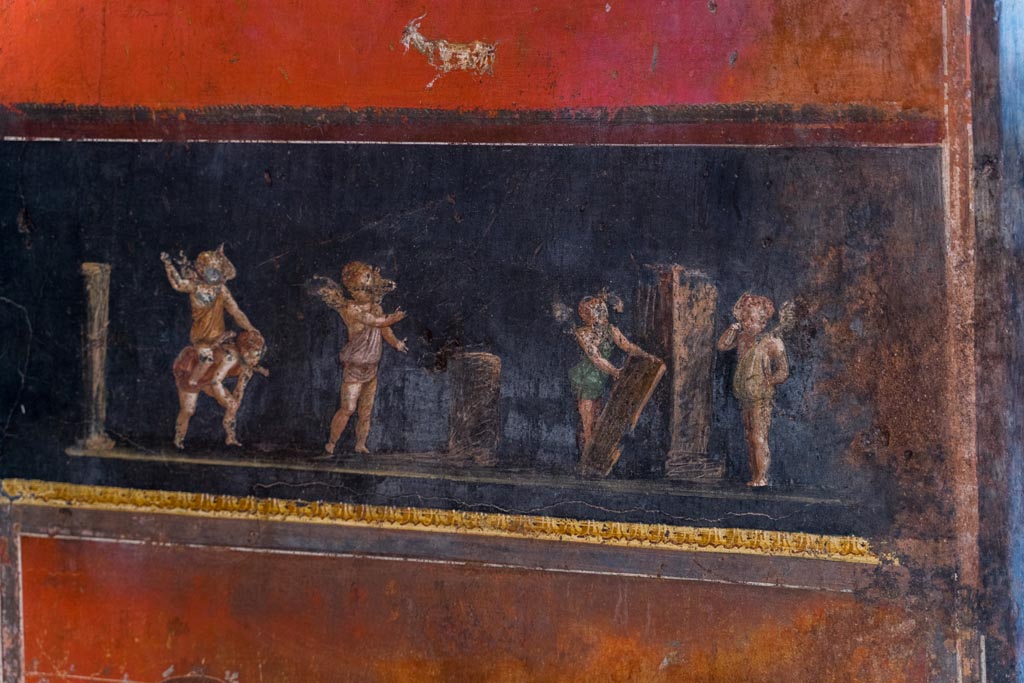 VI.15.1 Pompeii. March 2023. 
South wall in south-east corner with painting of cupids taking part in an archery or throwing contest. Photo courtesy of Johannes Eber.
