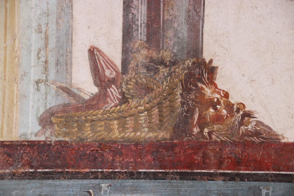 VI.15.1 Pompeii. October 2023. North wall of exedra with detail of basket and mask. Photo courtesy of Klaus Heese.