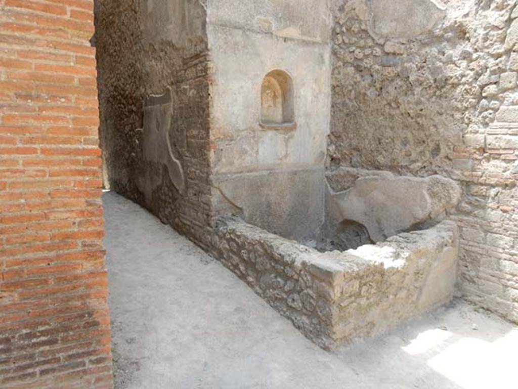 VII.1.46 Pompeii. May 2017. 
Looking north-west across kitchen 12 to niche lararium 14 built into west wall above a basin/tank.
On the left is the corridor with a small niche in its north wall.
Photo courtesy of Buzz Ferebee.

