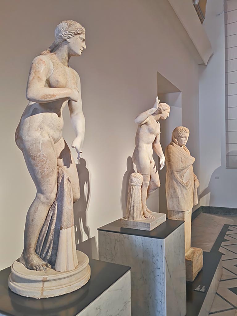 VII.7.32 Pompeii. April 2023. Portico of the Temple.
White marble statues of Aphrodite, Hermaphroditus, and herm of a cloaked Hermes.
Photo courtesy of Giuseppe Ciaramella.
