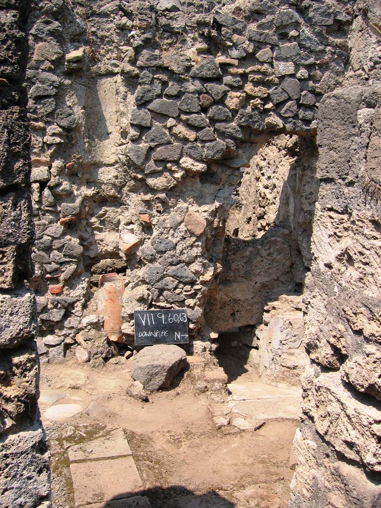 VII.9.63 Pompeii. July 2005. Looking west towards latrine. Photo courtesy of Barry Hobson.
According to Hobson, the original latrine was at the end of a narrow corridor to the north of the house.
Probably in the first century, this latrine was sealed over and replaced by a latrine in the room immediately to the left of the doorway.
This room might then have become a work area and perhaps housed the kitchen as well as the toilet.  
Next door to VII.9.63 a new entrance from the street was made, giving access via a staircase to the upper storey, and to the right of the stairs another new latrine was constructed.  
This was now back-to-back with the one in VII.9.63 and emptied into the same cesspit. 
In addition, the staircase led to an upper storey latrine, the down pipe from which was inserted into the wall.
The provision here of three latrines leads one to ask, who used each of them?  
See Hobson, B., 2009. Latrinae et foricae: Toilets in the Roman World. London; Duckworth. (p.68)
