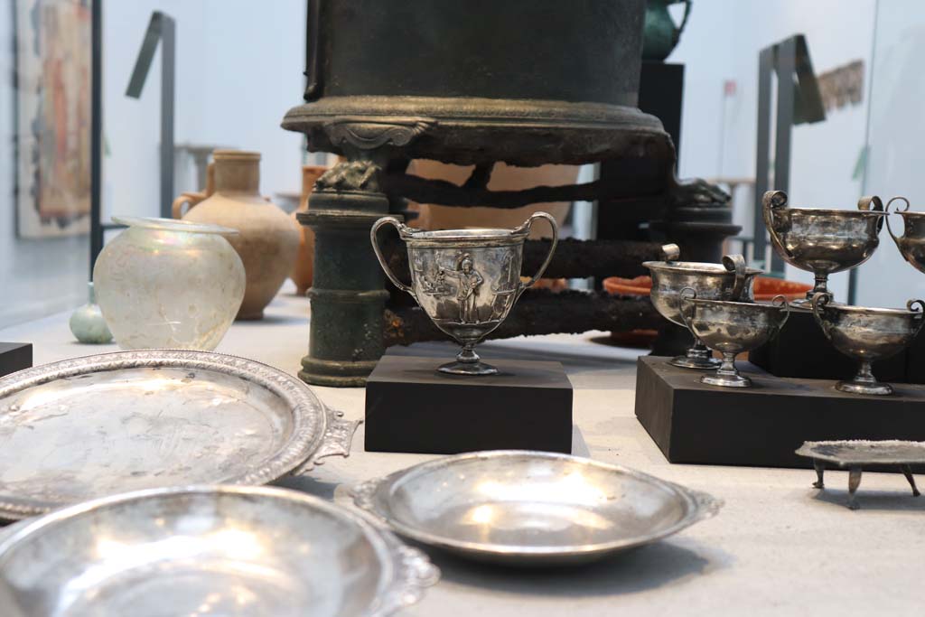 VIII.1.4 Pompeii. February 2021. Silver found in the Complex of the Moregine Triclinia.
Silver table set consisting of 20 pieces: a circular serving plate, four plates, ten cups – two embossed – four stands and a teaspoon.
The inscription, Erasti sum, engraved on the back of the silverware indicates that the owner’s name was Erastus.
Photo courtesy of Fabien Bièvre-Perrin (CC BY-NC-SA).

