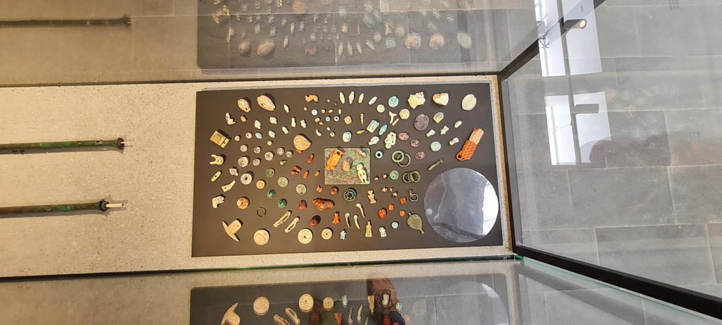 VIII.1.4 Pompeii. April 2022. Display case with amulets and gems found in V.3, House with Garden. Photo courtesy of Giuseppe Ciaramella.