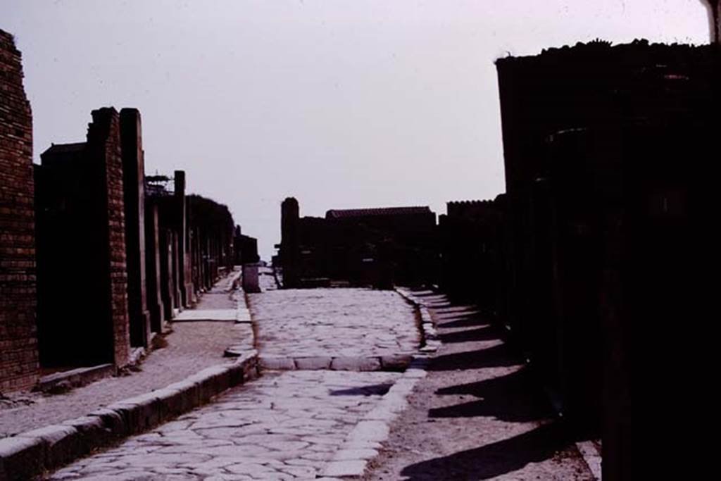Via dell’Abbondanza, Pompeii. 1975. Looking east between VII.1 and VIII.4. Photo by Stanley A. Jashemski.   
Source: The Wilhelmina and Stanley A. Jashemski archive in the University of Maryland Library, Special Collections (See collection page) and made available under the Creative Commons Attribution-Non Commercial License v.4. See Licence and use details. J75f0374
