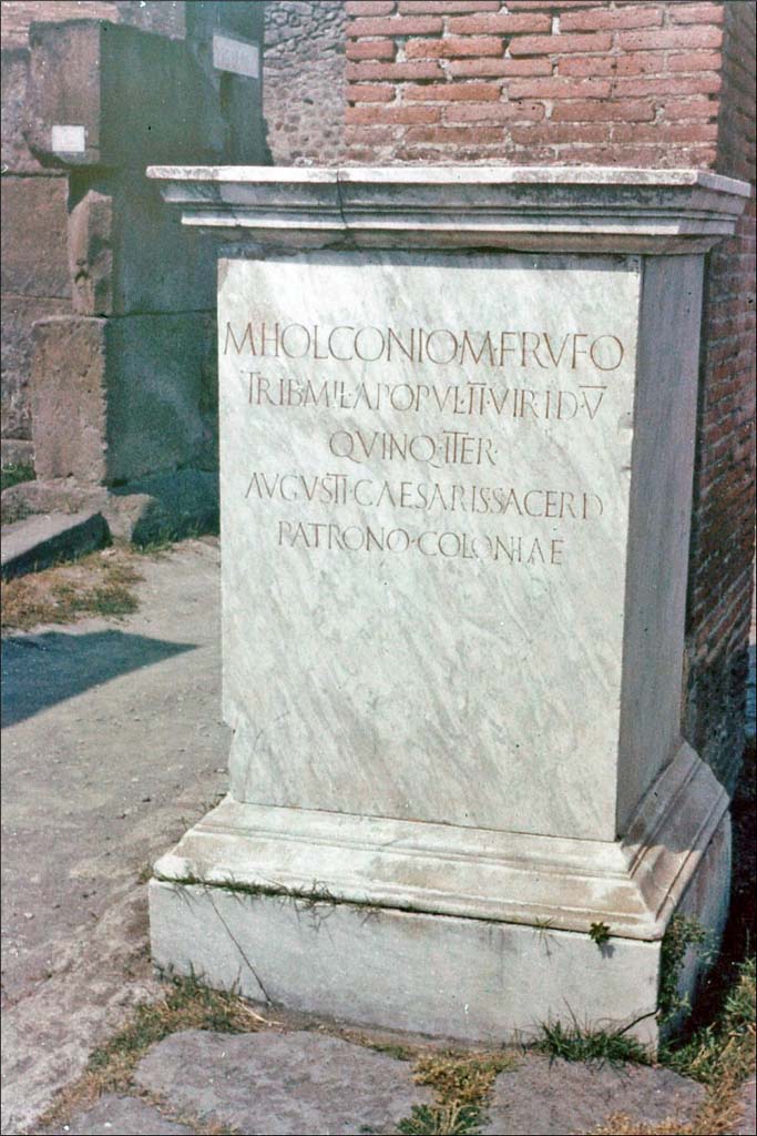 Via dell’Abbondanza, north side, Pompeii. June 1962. 
Statue base of Holconius Rufus near VII.1.11.
Photo by Brian Philp: Pictorial Colour Slides, forwarded by Peter Woods
(P43.18 POMPEII STREET INSCRIPTION)
