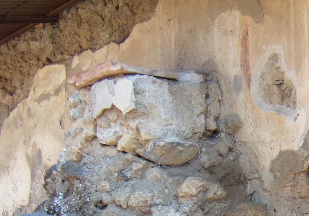 Pompeii Street Altar at I.8.1. September 2005. Rectangular altar with remains of plaste. On the wall behind can be seen the last coil of the serpent which had its head over the offering on the altar.