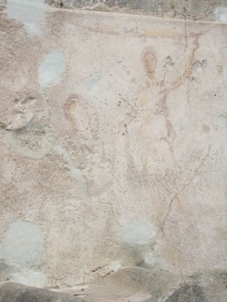 Pompeii street altar on west side wall of I.11.1. May 2006. 
Remains of painting above altar. The right hand Lar can be seen with his left hand raised holding a cornucopia. A curving line flows from the cornucopia, above his head and down to the situla (bucket) in his right hand. The curve of the serpent can be seen above the top of the painted round altar. 
The head is down to the left reaching into the burning offering on the top of the altar.  The garland can be seen above the Lar.

