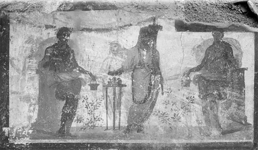 Street shrine outside IX.12.7. Detail from 1912 photograph.
Top right of the four paintings was a painting of two Lares in green tunics leaning on pillars. 
A genius was making a sacrifice at a portable altar. 
Three other similar people from an older picture were also visible through the white background. 
See Fr�hlich, T., 1991. Lararien und Fassadenbilder in den Vesuvst�dten. Mainz: von Zabern. (p. 339, F71, T: 58,2). 
