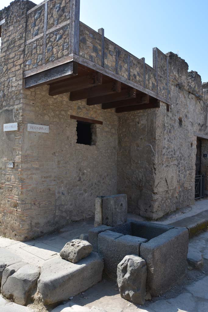 Fountain at I.10.1 Pompeii. April 2017. 
Looking towards corner of Vicolo di Menandro (on right) at junction with Vicolo di Paquius Proculus (on left). .
Photo courtesy Adrian Hielscher.
