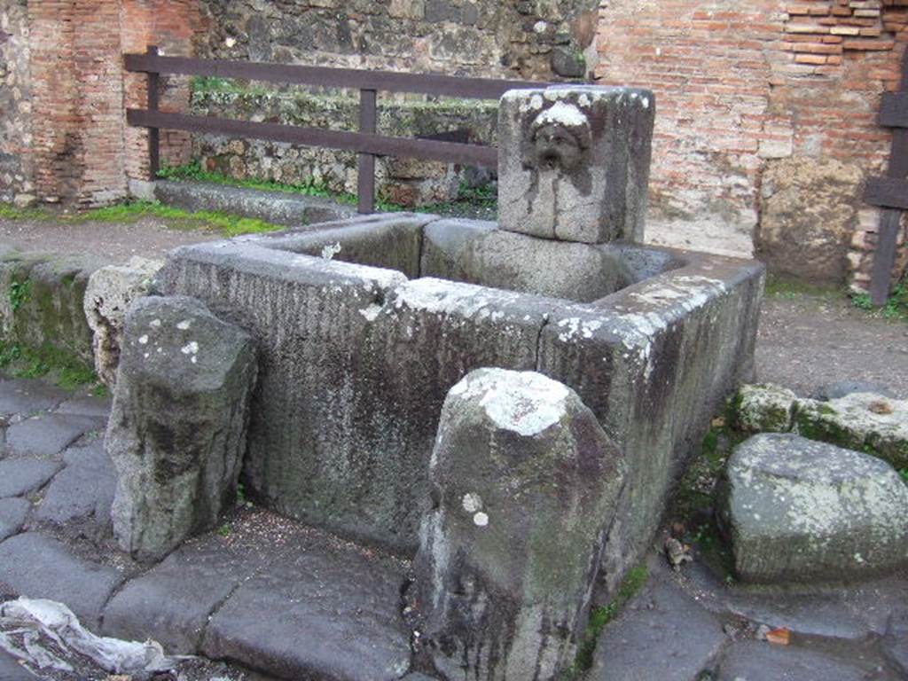 Fountain outside VII.1.32 and VII.1.33, December 2005. Looking south-west.
According to Eschebach, opposite the fountain was the street shrine of the lares compitales. See Eschebach, L., 1993. Geb�udeverzeichnis und Stadtplan der antiken Stadt Pompeji. K�ln: B�hlau. (p.249)
 
