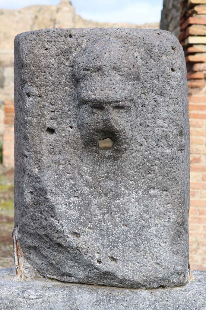 Fountain outside VII.14.13 and VII.14.14 on north side of Via dell�Abbondanza. December 2018.  
Head with helmet, possibly a relief of Minerva. Photo courtesy of Aude Durand.
