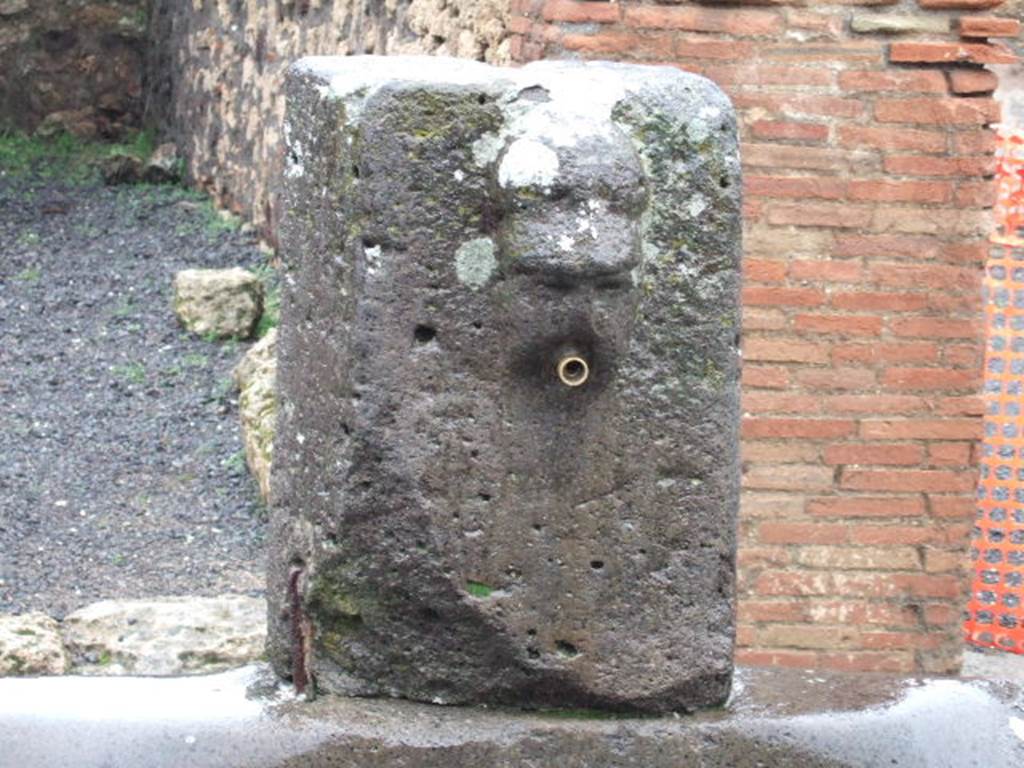 Fountain outside VII.14.13 and VII.14.14 on Via dell�Abbondanza. December 2005. 
Head with helmet, possible relief of Minerva.
