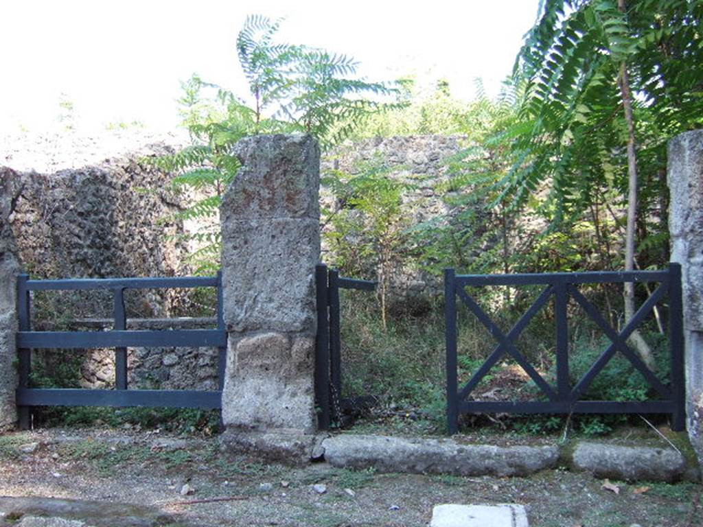 I.1.1 Pompeii. September 2005. Looking east from Via Stabiana towards the double entrance, divided by a pillar. According to Fiorelli, the Caupona was held by an Epagato, that had a deformity of either his head or his body (del capo o del corpo), and because of this he was called “cilo”, and this name was found on a pillar to the right of the entrance in an electoral recommendation (now  no longer there) – 
CEIVM . II . V.I.D 
EPAGATVS . GYLO
      ROG
According to Della Corte, the electoral recommendation read:  “EPAGATUS COPO ROG(AT)”  [CIL IV. 1015]
See Pappalardo, U., 2001. La Descrizione di Pompei per Giuseppe Fiorelli (1875). Napoli: Massa Editore. P.32, in which he writes that he cannot concede the correction proposed by Zangmeister of  CITO or COPO (CIL. IV.1015), as he says the upper part of a Y and the lower part of an L, were visible.

