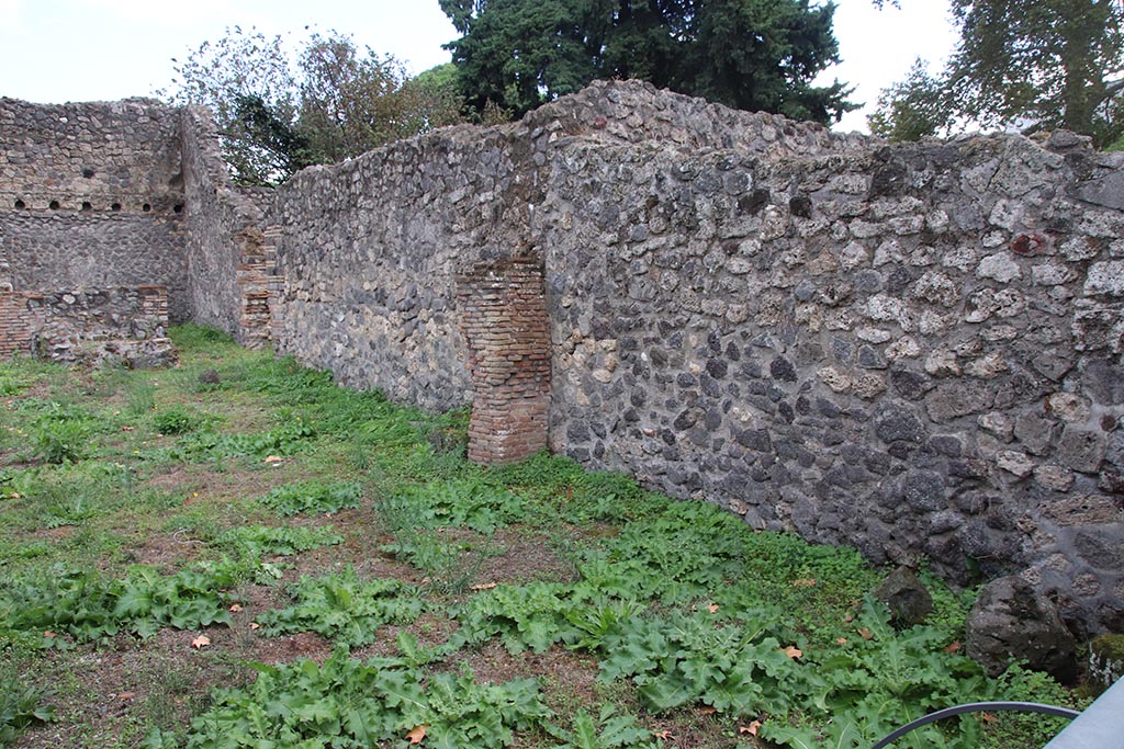 I.1.3 Pompeii, October 2024. 
Room “a”, south wall, on right, with south wall of room “b” and yard “c”, centre left, with doorway into room “f” at rear, on left. 
Photo courtesy of Klaus Heese.
