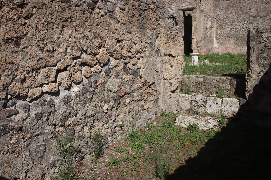 I.2.9 Pompeii. October 2024. 
North wall in north-east corner, with three steps in east wall into atrium of I.2.10. Photo courtesy of Klaus Heese.
