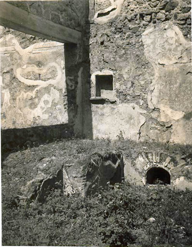 I.2.10 Pompeii. 1935 photo taken by Tatiana Warscher. Looking towards north wall of garden area with niche. On the left of the photo is the north wall of the triclinium, the wall with window overlooking garden area can also be seen on the left. On the right, the storage area under the north couch is visible.
See Warscher T., 1935. Codex Topographicus Pompeianus: Regio I.2. (no.22), Rome: DAIR, whose copyright it remains.