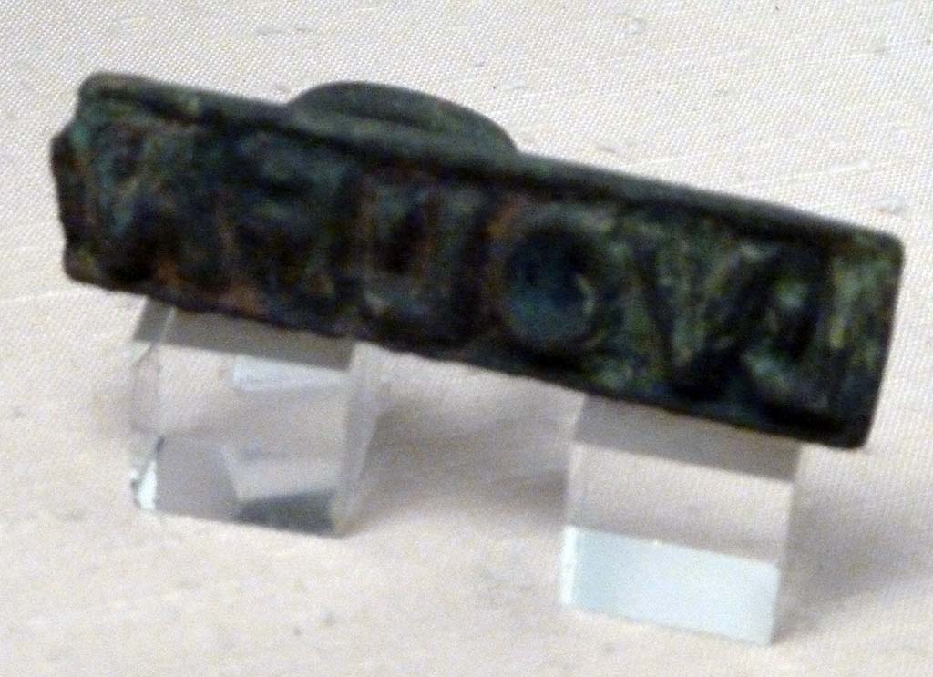 I.2.10 Pompeii. Found in the atrium. Ring seal with the name of L(ucius) VOL(usius) FAV(stus)
Now in Naples Archaeological Museum. Inventory number 109689.
According to Della Corte, perhaps the seal belonged to the head of the family – L. Vol(usius) Fau(stus) (S.106) (CIL X 8058, 96).
He may have been a manufacturer of liquamen, as from an inscribed pitcher found here – M. Volusi(us) Fau(stus).
These citizens, living in the same house, may have been brothers.
See Della Corte, M., 1965. Case ed Abitanti di Pompei. Napoli: Fausto Fiorentino. (p.264 and note 3).
Della Corte noted that despite the diligence of Zangemeister, he did not register and number the writing on the pitcher in CIL IV.
This epigraph had been reported by Fiorelli.