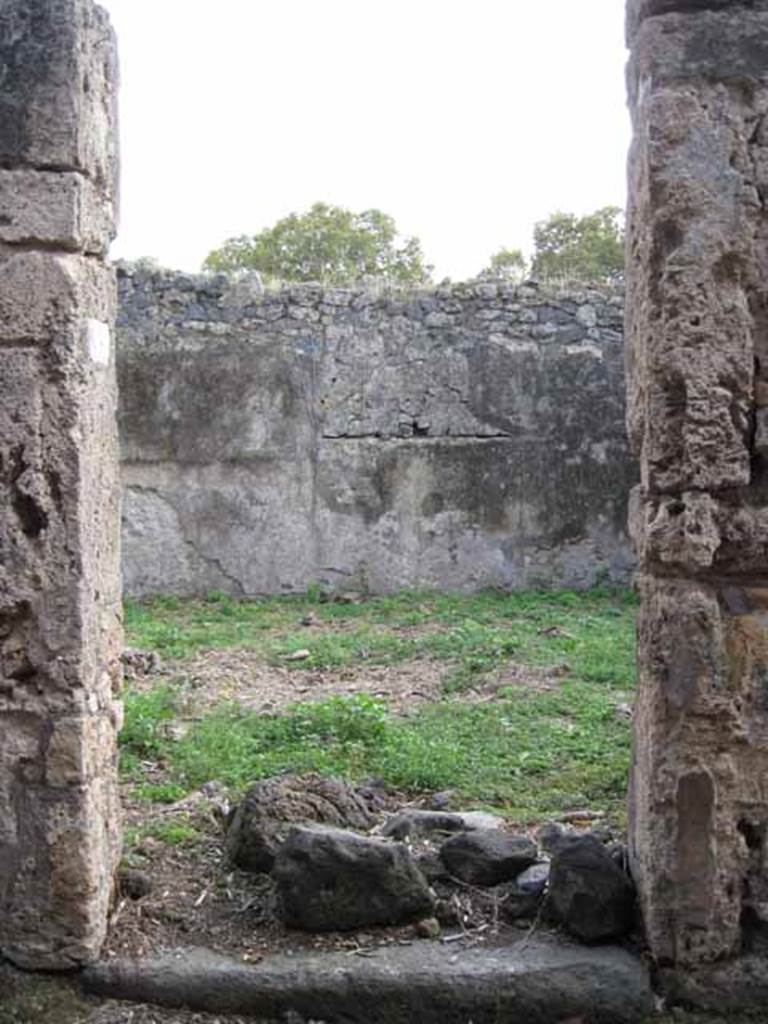 I.2.15 Pompeii. September 2010. Looking south to entrance doorway.
Photo courtesy of Drew Baker.
According to Warscher, quoting Fiorelli, she wrote � �I.2.15, una casa che apparteneva a persona di umile condizione e che ricorda la casa primitiva di Pompei: consiste dell�atrio �a�, due cubicoli e di una fauce che menava alla cucina, alla stalla, ad�una apotheca, alla latrina, ed a una gradinata di fabbrica per le stanze superiori�.
See Warscher T., 1935. Codex Topographicus Pompeianus: Regio I.2. Rome: DAIR.
(translation: "I. 2.15, a house that belonged to a person of humble condition and reminiscent of primitive houses of Pompeii: consisting of an atrium �a�, two cubiculae, and a corridor that led to the kitchen, to the stable, and to a storeroom, to the latrine, and to a masonry staircase to the upper rooms.�) 
