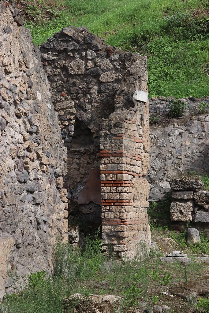 I.2.23 Pompeii. October 2024. 
Looking east towards entrance doorway on north side of Vicolo del Conciapelle. Photo courtesy of Klaus Heese.
