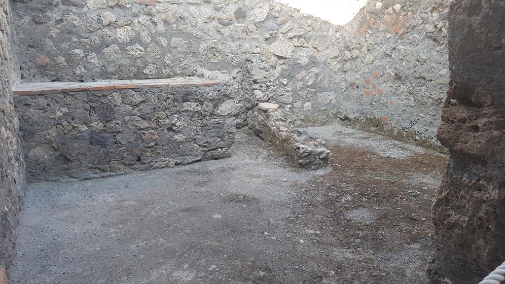 I.6.4 Pompeii. August 2023.
Room 8, looking through doorway towards east wall with hearth, on left, and latrine, on right. Photo courtesy of Maribel Velasco.