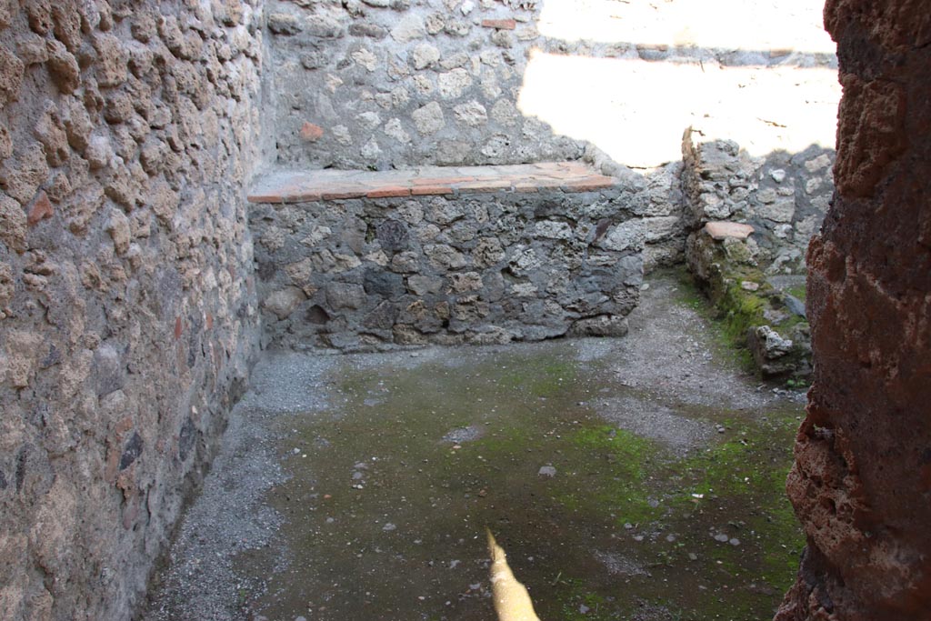 I.6.4 Pompeii. October 2022. Room 8, looking east through doorway towards hearth/bench. Photo courtesy of Klaus Heese.