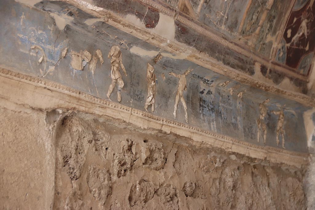 I.6.4 Pompeii, October 2024. Room 16, sacellum. Frieze on east side. The mule cart carrying the body of Hector. Photo courtesy of Klaus Heese.