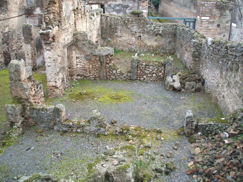 I.6.13 Pompeii. December 2004.  West side looking south, photo taken from rear of I.6.11.
Triclinium 4 would appear to be the large room across the centre of the photo.
Room 7 can be seen on the lower left, room 10 on the lower right.
On the north side of room 10, (but not in the above photo) would have been a small room.
This was described on page 433 of Notizie degli Scavi, 1929, -
�as a second corridor �f� used to separate the narrow rooms 8-9-10 and corresponding to a side doorway to the western vicolo, with a wooden staircase giving access to the upper floor, a doorway that would have been closed or abolished at the time of the abandonment of the house, after the 63 earthquake.�
Room 9 would have been a small room in the north-west corner of the house.
