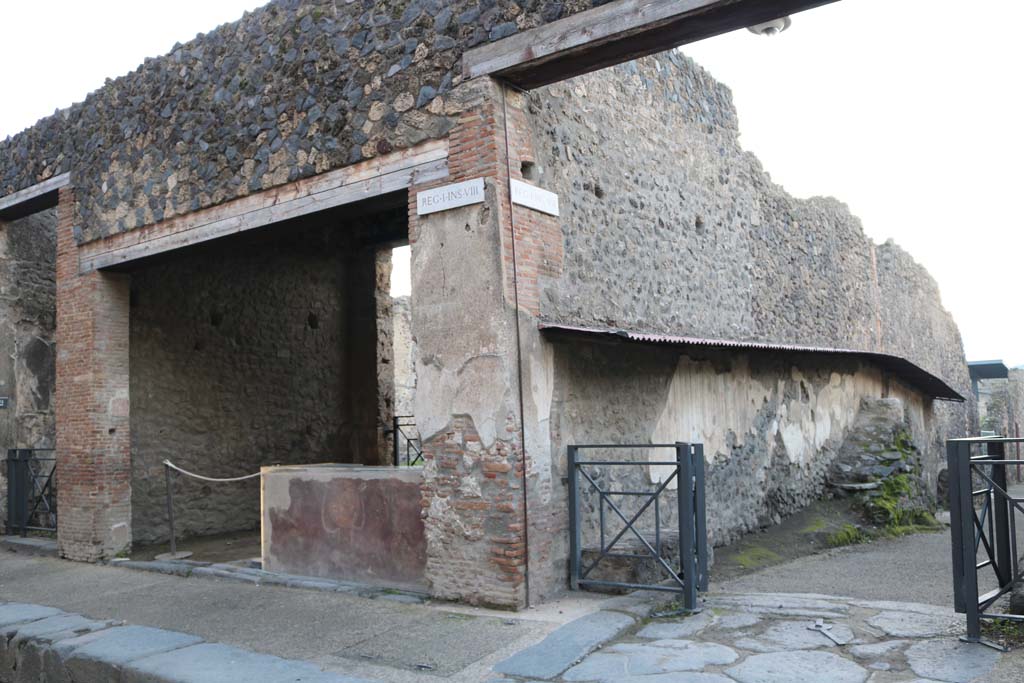 I.8.1, on left, Via dell’Abbondanza, south side. December 2018. 
Looking south-east towards east wall of Vicolo dell’Efebo between I.8 and I.7, with street altar, on right. Photo courtesy of Aude Durand.

