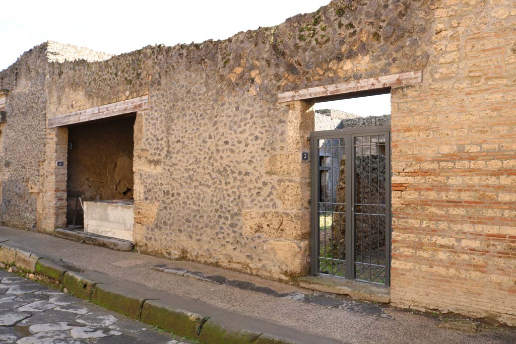 I.9.3 Pompeii, on right, and I.9.4, on left. December 2018. 
Entrance doorways on south side of Via dell�Abbondanza. Photo courtesy of Aude Durand.
