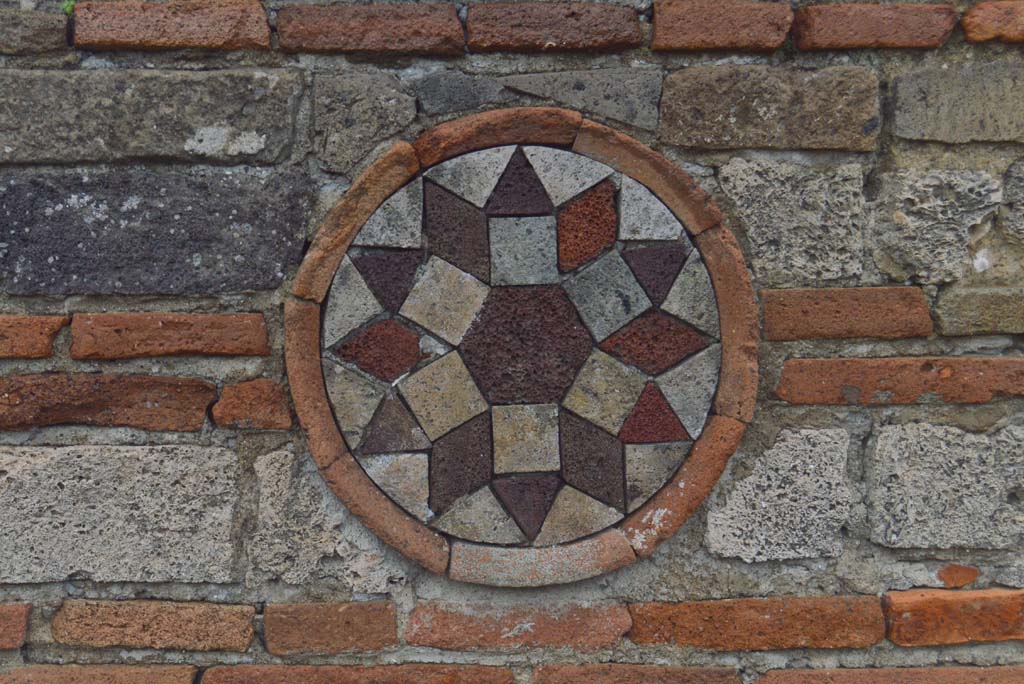 I.10.9 Pompeii. March 2018. Coloured terracotta decorated circular plaque on upper north side of entrance. 
Foto Taylor Lauritsen, ERC Grant 681269 DÉCOR.

