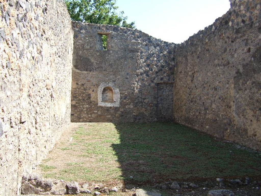 I.11.13 Pompeii. September 2005. Looking east across garden area.
According to Jashemski, the garden had a portico on the west (nearest) side supported by one column. A low wall separated the garden from the portico. There is an arched niche Lararium on the east wall. See Jashemski, W. F., 1993. The Gardens of Pompeii, Volume II: Appendices. New York: Caratzas. (p.52)  Neither the one column on the portico nor the low wall appear to be there anymore.
