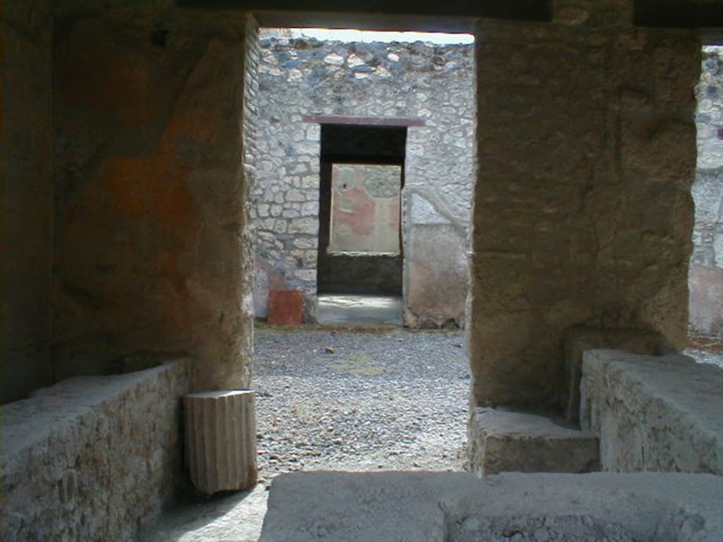 I.12.5 Pompeii. September 2004.
Looking south through rear of caupona across atrium to doorway to triclinium with window onto garden.