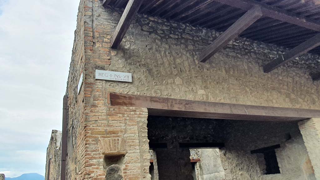 I.12.5 Pompeii. July 2021. 
Looking towards upper front facade on south side of Via dell’Abbondanza with Vicolo dei Fuggiaschi, on left.
Foto Annette Haug, ERC Grant 681269 DÉCOR.
