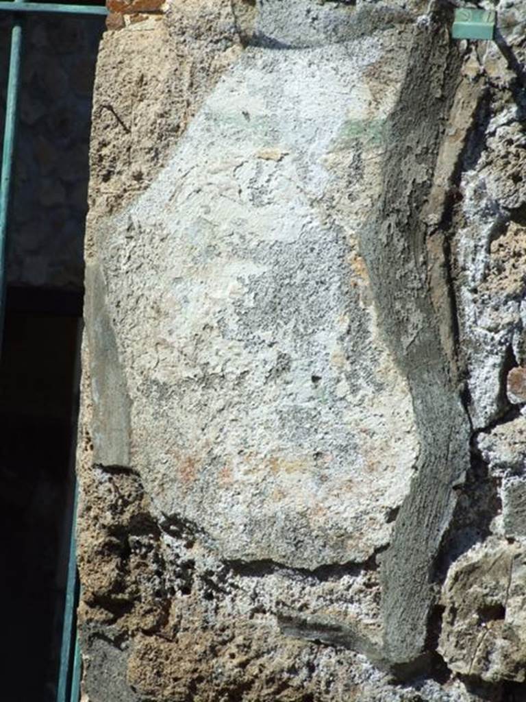 I.12.11 Pompeii. March 2009.  Remains of painted plaster on east side of doorway, which was the site of the wall painting of Hercules. The remains of the �garland� are just visible.

