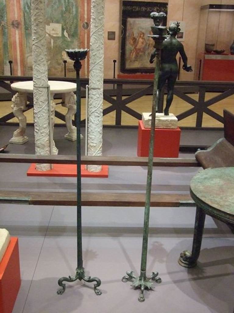 I.13.1 Pompeii.  Bronze candelabrum (on left). This has a tripod base with lion's paw feet with a lanceolate leaf over each one, and top decorated with leaves.  SAP 11354. Photographed at “A Day in Pompeii” exhibition at Melbourne Museum.  September 2009.