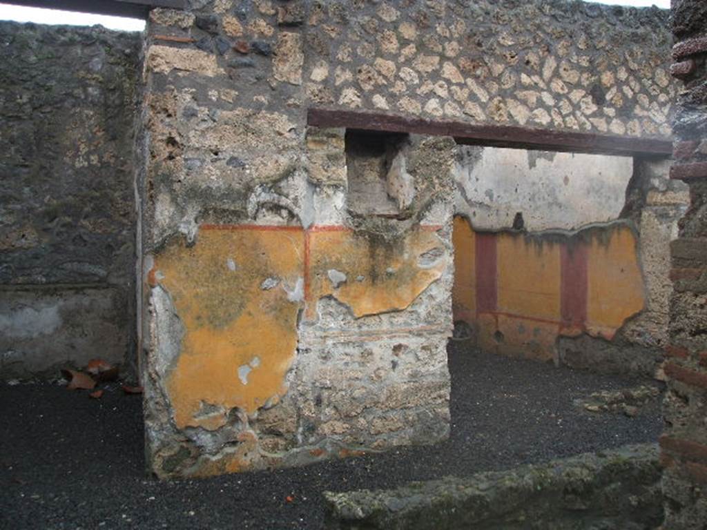 I.13.11 Pompeii. December 2004. Looking west across garden area.
Doorways to cubiculum on left, and oecus on the right, on west side of garden, with lararium niche between. According to PPP, on the west wall between doorways was the lararium niche, with serpent, red flowers and red border, much decayed. See Bragantini, de Vos, Badoni, 1981. Pitture e Pavimenti di Pompei, Parte 1. Rome: ICCD. (p.189)
According to Fr�hlich and Giacobello, the rectangular niche was painted on its inside walls with red flowers, no longer conserved.  There may have been two statuettes found in this lararium, Hercules and Minerva.
See Fr�hlich, T., 1991. Lararien und Fassadenbilder in den Vesuvst�dten. Mainz: von Zabern. (L31)
See Giacobello, F., 2008. Larari Pompeiani: Iconografia e culto dei Lari in ambito domestico.  Milano: LED Edizioni. (p.233)
According to PPM, the lower yellow zoccolo was divided into two panels by a vertical red band. On the south end was a painted vignette showing two doves with cherries, and at the north end under the niche was the painted lararium showing two serpents approaching a central altar with eggs.
See Carratelli, G. P., 1990-2003. Pompei: Pitture e Mosaici. Vol.II  Roma: Istituto della enciclopedia italiana. (p.916).


