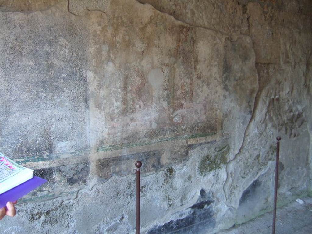 I.16.5 Pompeii. September 2005. Remains of central painting on painted wall in room on east side of peristyle.